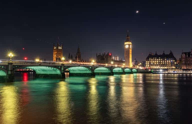 Stunning night scene of Big Ben and Westminster Bridge in London, reflected in the Thames.