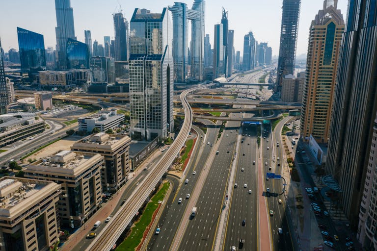 Aerial view capturing the dynamic skyline and highways of Dubai, UAE, showcasing modern architecture.