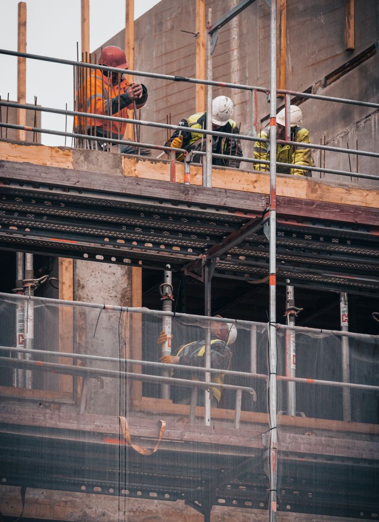 The MAR Legal Blog 3 Construction workers engage in building tasks on a scaffold in Hamburg.
