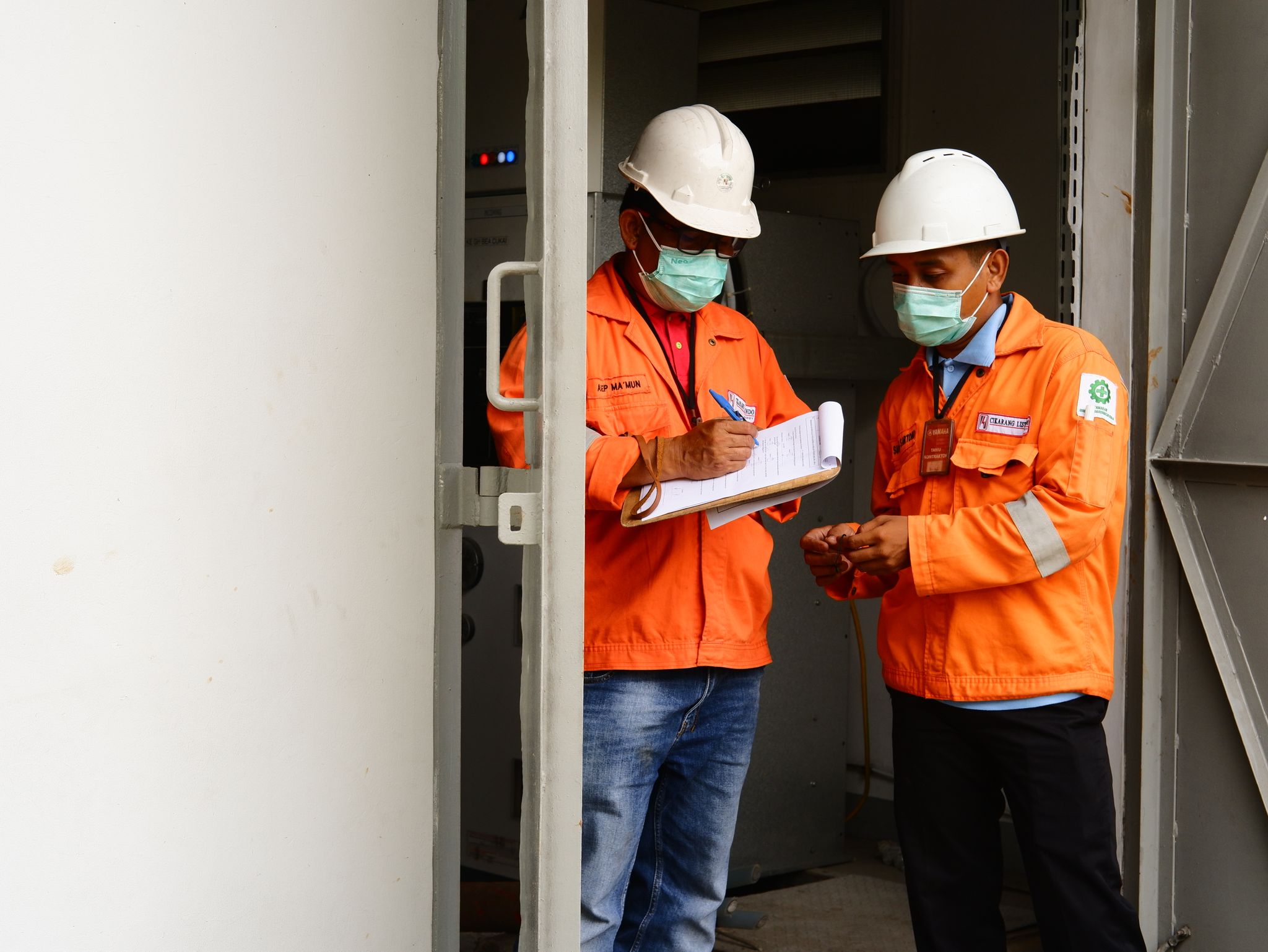 Construction Lawyers Manchester 1 Two construction workers in safety gear discussing plans at a site entrance.